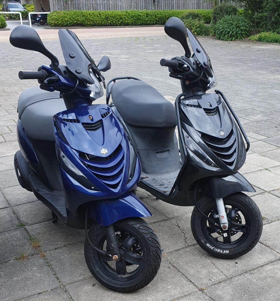 2 piaggio zip scooters, een blauwe en zwarte, na onderhoud en een nieuwe band bij bromfix 
